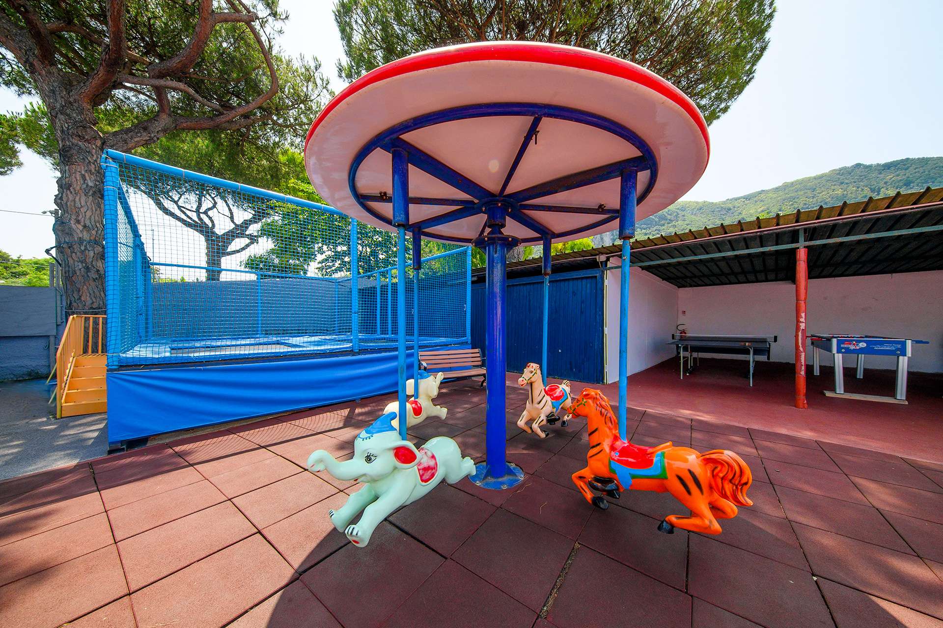 Giostrina con elefantini e cavallini, trampolino elastico, ping-pong e calcio balilla per i bambini