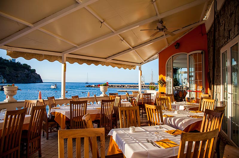 Sala del ristorante con vista sulla terrazza e sul mare